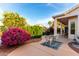 Inviting covered patio area with a table set and vibrant landscaping at 3781 N 161St Dr, Goodyear, AZ 85395