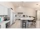 Open kitchen boasts white cabinets, tiled floors, bar seating, a desk, and abundant natural light at 3781 N 161St Dr, Goodyear, AZ 85395