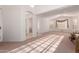 Open-concept living room with arched doorways, shuttered windows, and carpeted floors at 3781 N 161St Dr, Goodyear, AZ 85395