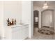 Functional wet bar area with white cabinetry, sink, and view of the front entrance at 3781 N 161St Dr, Goodyear, AZ 85395