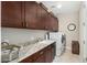 Organized laundry room featuring a sink, generous counter space, ample storage cabinets, and modern washer-dryer at 3945 E Cherry Hills Dr, Chandler, AZ 85249