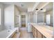 Bright primary bathroom featuring dual sinks, a soaking tub, and a walk-in closet at 4001 E Rosemonte Dr, Phoenix, AZ 85050