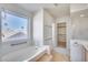 Bright bathroom featuring a soaking tub, walk-in closet, and lots of sunlight at 4001 E Rosemonte Dr, Phoenix, AZ 85050