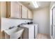 Bright laundry room with washer, dryer, sink, lots of storage, and natural light at 4001 E Rosemonte Dr, Phoenix, AZ 85050