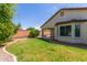 Spacious backyard with green lawn, beautiful landscaping, and a brick fence at 4094 E Los Altos Dr, Gilbert, AZ 85297