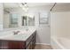 Bathroom with double sinks, dark wood cabinets, and a tub at 4094 E Los Altos Dr, Gilbert, AZ 85297