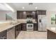 Stylish kitchen with stainless steel appliances, granite countertops, and dark wood cabinetry at 4094 E Los Altos Dr, Gilbert, AZ 85297