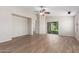 Spacious living room with wood-look tile flooring, a ceiling fan, and sliding glass door to backyard at 4094 E Los Altos Dr, Gilbert, AZ 85297