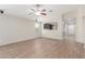 Open-concept living room with wood-look tile flooring, a ceiling fan, and view to the kitchen at 4094 E Los Altos Dr, Gilbert, AZ 85297