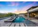 Backyard with a pool, spa, and desert landscaping creates a serene desert oasis at 4098 N Golf Dr, Buckeye, AZ 85396