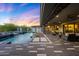 Outdoor living space with a pool, spa, covered patio, and desert landscaping at dusk at 4098 N Golf Dr, Buckeye, AZ 85396