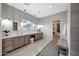 Bright bathroom showcasing dual vanities, stone flooring, and an organized walk-in closet at 4098 N Golf Dr, Buckeye, AZ 85396