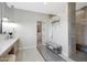 Bright bathroom showcasing a sleek bench, stone flooring, art display and a glass-enclosed shower at 4098 N Golf Dr, Buckeye, AZ 85396