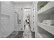 Modern bathroom with white subway tile shower, gray decorative floor tile, and built-in shelving at 4098 N Golf Dr, Buckeye, AZ 85396