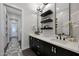 Modern bathroom with double sinks, dark cabinets and floating shelving with decor at 4098 N Golf Dr, Buckeye, AZ 85396