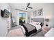 Bedroom with a large window, gray carpet, and a bed with stylish bedding and pillows at 4098 N Golf Dr, Buckeye, AZ 85396