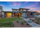 Inviting two-story home featuring a modern design, manicured lawn, stone accents, and a welcoming entrance with custom walkway at 4098 N Golf Dr, Buckeye, AZ 85396