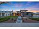 Stunning two-story home with modern design, manicured lawn, stone accents, and a welcoming entrance with blooming trees at 4098 N Golf Dr, Buckeye, AZ 85396