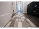 Hallway with decorative tile flooring leading to another room, white walls and doors at 4098 N Golf Dr, Buckeye, AZ 85396