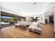 Bright living room with hardwood floors, large sectional, and sliding doors to outdoor patio at 4098 N Golf Dr, Buckeye, AZ 85396