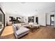 Spacious living room with a sectional couch, wooden floors, and view of kitchen at 4098 N Golf Dr, Buckeye, AZ 85396