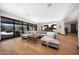 Open-concept living room with hardwood floors, a large sectional sofa, and seamless access to the outdoor patio at 4098 N Golf Dr, Buckeye, AZ 85396