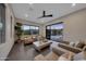 A modern living room features neutral furniture, tile floors, and glass doors that open to an outdoor pool area at 4098 N Golf Dr, Buckeye, AZ 85396