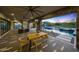 A covered patio boasts a dining area, lounge, and a view of the pool and mountains at 4098 N Golf Dr, Buckeye, AZ 85396
