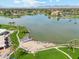 Aerial view of lake with beach and dock surrounded by lush green lawns and tall palm trees at 7401 N Scottsdale Rd # 24, Paradise Valley, AZ 85253