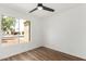 This bedroom features a ceiling fan, wood look flooring, and a window with natural light at 747 W Rice Dr, Tempe, AZ 85283