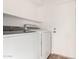 A laundry room features a side-by-side washer and dryer, white shelving, and a back door at 747 W Rice Dr, Tempe, AZ 85283