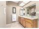 Well lit bathroom with wood cabinets, granite countertops and a large mirror at 8011 E Milagro Ave, Mesa, AZ 85209