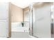 Bathroom featuring a soaking tub, a shower, and frosted glass windows at 8011 E Milagro Ave, Mesa, AZ 85209