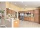 Spacious kitchen with stainless steel refrigerator, granite countertops and wooden cabinetry at 8011 E Milagro Ave, Mesa, AZ 85209