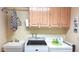 Functional laundry room with wooden cabinets, washer, dryer, and sink for added convenience at 8020 E Keats Ave # 279, Mesa, AZ 85209