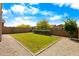 A well-maintained backyard features lush green grass, rock ground covering and a secure privacy wall at 9229 W Willow Bend Ln, Phoenix, AZ 85037