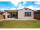 Backyard features green grass, large windows, and covered patio offering serene outdoor living at 9229 W Willow Bend Ln, Phoenix, AZ 85037