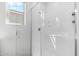 Walk-in shower with clear glass door, window, and chrome fixtures at 9229 W Willow Bend Ln, Phoenix, AZ 85037