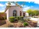 Charming stucco home showcasing desert landscaping, an arched window and entrance, and a two-car garage at 9229 W Willow Bend Ln, Phoenix, AZ 85037