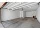 Spacious two car garage with concrete floor, white walls and an automatic door at 9229 W Willow Bend Ln, Phoenix, AZ 85037