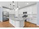 Spacious kitchen showcasing a large island, stainless appliances, white cabinets, and pendant lighting at 9229 W Willow Bend Ln, Phoenix, AZ 85037