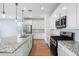 Modern kitchen boasts granite countertops, subway tile backsplash, stainless appliances, and island with sink at 9229 W Willow Bend Ln, Phoenix, AZ 85037