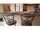 Kitchen bar features two stools and countertop with decorative elements and lighting overhead at 930 N Mesa Dr # 2027, Mesa, AZ 85201