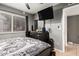 A gray bedroom features a bed with monochrome sheets, a ceiling fan, and a mounted TV at 10723 N 80Th Ln, Peoria, AZ 85345