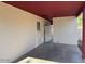 Exterior view of a covered patio featuring painted concrete flooring and a white privacy wall with a small window at 120 N Jackson St, Chandler, AZ 85225