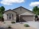 A beautiful single-story home with a two-car garage, gravel landscaping, and a well-kept lawn at 13193 E Verbina Ln, Florence, AZ 85132