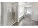 Modern bathroom featuring a glass-door shower, a tub, and neutral tile flooring at 13481 W Buckskin Trl, Peoria, AZ 85383