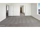 Large bedroom with neutral carpet, multiple doorways, and a bright window at 13481 W Buckskin Trl, Peoria, AZ 85383
