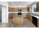 Spacious kitchen with a center island, light wood cabinets, and granite countertops at 13481 W Buckskin Trl, Peoria, AZ 85383