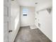 Well-lit laundry room features gray tile flooring, a window, and washer/dryer hookups at 13481 W Buckskin Trl, Peoria, AZ 85383